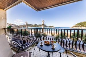 a table and chairs on a balcony with a view of the ocean at LA CONCHA BEACHVIEW apartment in San Sebastián