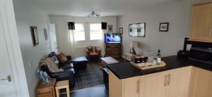 uma sala de estar com um sofá e uma televisão em Ben Lomond Cottage em Arrochar