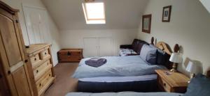 Habitación pequeña con cama y ventana en Ben Lomond Cottage, en Arrochar