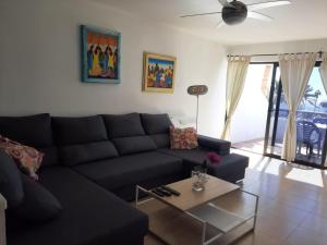 sala de estar con sofá negro y mesa en Auremar, en Puerto del Carmen