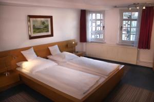 a bedroom with a bed with white sheets and pillows at Haus Oberscholtes in Grünberg