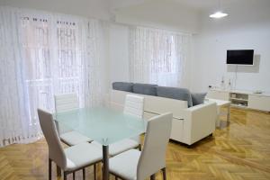 a living room with a glass table and white chairs at Beautiful Renovated Flat in Athens (The Dem Flat) in Athens