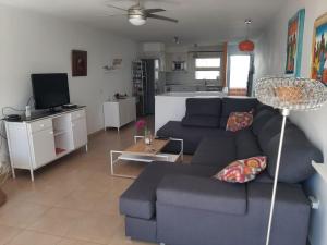 sala de estar con sofá azul y TV en Auremar en Puerto del Carmen