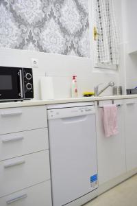 a white kitchen with a microwave and a dishwasher at Beautiful Renovated Flat in Athens (The Dem Flat) in Athens