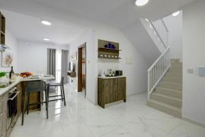 cocina con suelo de baldosa blanca y escalera en Chic 2BR Penthouse steps from the Promenade, en Sliema
