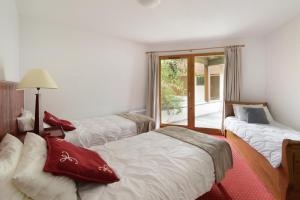 a room with three beds and a window at Goélia Les Chalets des Deux Domaines in Peisey-Nancroix