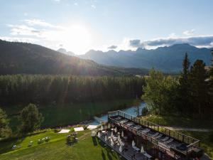 een trein die langs een rivier langs een berg rijdt bij Grand Hotel Kronenhof in Pontresina