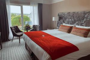 una camera d'albergo con un grande letto e una finestra di Killaloe Hotel & Spa a Killaloe