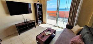 a living room with a couch and a flat screen tv at Playa Paraiso-Apartment 4 you in Costa Calma