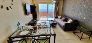 sala de estar con mesa y sofá en Playa Paraiso-Apartment 4 you, en Costa Calma