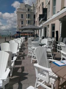 a row of white chairs and tables on a patio at The Old Ship Hotel in Brighton & Hove