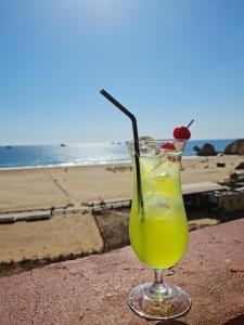 a drink sitting on a ledge next to the beach at Portugal Algarve Beach Apartment in Portimão