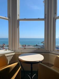 a room with two chairs and a table in front of windows at The Old Ship Hotel in Brighton & Hove