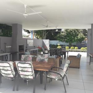 un patio con mesa de madera y sillas en Aflica Apartments en Gaborone