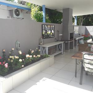 um pátio com flores, uma mesa e cadeiras em Aflica Apartments em Gaborone