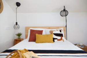 a bedroom with a bed with colorful pillows at La casita de Canido in Oya
