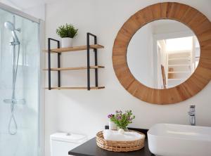 a bathroom with a wooden mirror and a sink at La casita de Canido in Oya +23 photos