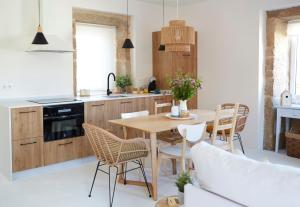 a kitchen with a wooden table and chairs at La casita de Canido in Oya