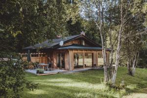 una baita di tronchi nel bosco con un tavolo nel cortile di Die Lärchen-Lodge a Maishofen