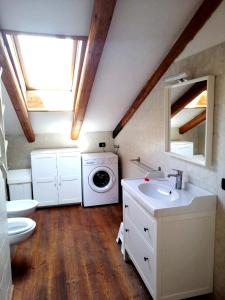 a bathroom with a sink and a washing machine at Casa Leonilla in Pellizzano