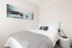a bedroom with a white bed with a picture on the wall at 2Bedroom apartment in a secure golf estate.WIFI in Roodepoort +18 photos