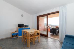 salon ze stołem i niebieską kanapą w obiekcie Appartamento con piscina 14 w mieście Trinità dʼAgultu