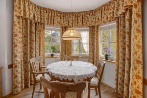 - une salle à manger avec une table, des chaises et des fenêtres dans l'établissement Seeberg - Haus Annamirl, à Bayrischzell