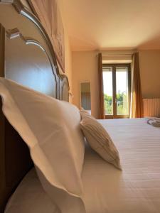 a bedroom with a bed with a pillow and a window at Al Laghetto La Morra in La Morra