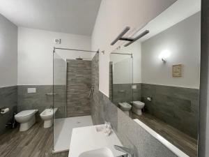 uma casa de banho com 2 WC e uma cabina de duche em vidro. em Al Laghetto La Morra em La Morra