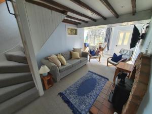 a living room with a couch and a staircase at Cromla Cottage in Corrie