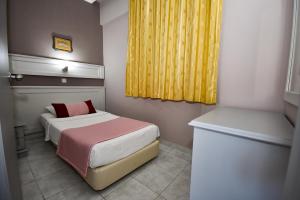 a small bedroom with a bed and a yellow curtain at Pasahan Apartments in Marmaris