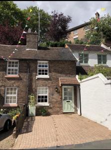 a brick house with a driveway in front of it at Bramble cottage with free parking in Bridgnorth