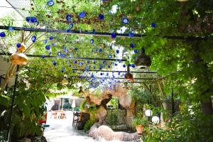 a garden with blue glass balls hanging from a pergola at Pasahan Apartments in Marmaris