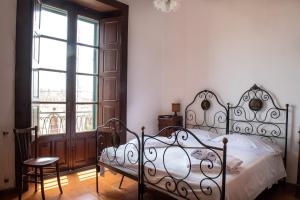 a bedroom with a bed and a chair and a window at Florence Trevelyan Villa in Letojanni