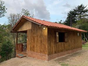 a small wooden building with a open door at Sítio-Estalagem Pouso-Frio in Cunha