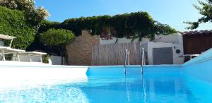 a swimming pool with blue water in front of a house at B&B Aly&Emy in Limpiddu