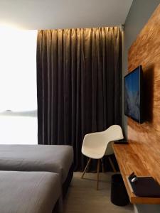 een hotelkamer met een bed, een bureau en een stoel bij CASA CHICA in El Calafate
