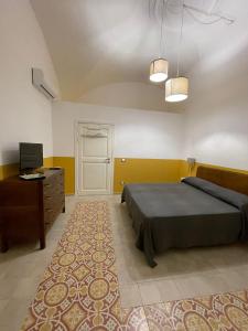 a bedroom with a bed and a dresser and a door at L'Armonia in Gaeta