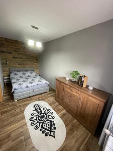 a bedroom with a bed and a table and a rug at Apartamentylove - Apartament u Janicka, 100m do Krupówek in Zakopane