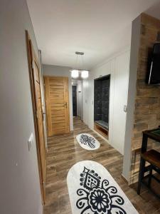 a room with a hallway with a door and wooden floors at Apartamentylove - Apartament u Janicka, 100m do Krupówek in Zakopane