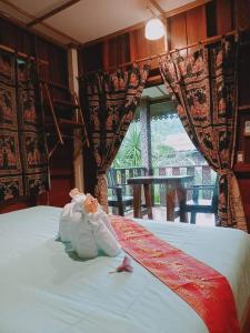 1 dormitorio con 1 cama blanca y ventana en Khao Sok River & Jungle Resort, en Khao Sok