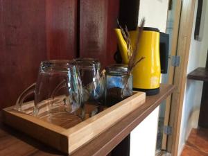 a wooden shelf with glasses and a yellow container on it at Khao Sok River & Jungle Resort in Khao Sok National Park