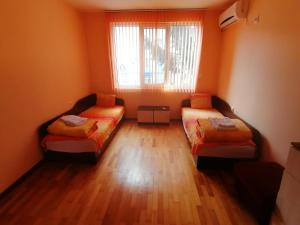 YambolにあるMarlene Apartmentのベッド2台と窓が備わる小さな客室です。