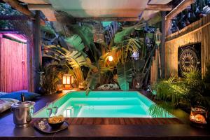 uma banheira num quarto com plantas em Naturarte Suites em Terrasini