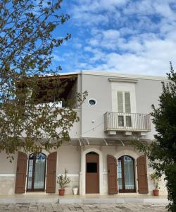 a large white building with a balcony on top of it at Tenuta Vigna del Noce in Corato