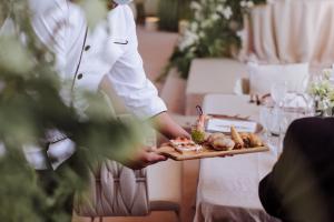 une personne tenant un plateau de nourriture sur une table dans l'établissement Azul Talavera Country Club, à Torreón