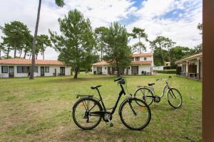 two bikes parked in the grass in a yard at Résidence Sous les Pins (by Popinns) in Ronce-les-Bains