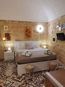 een slaapkamer met een groot bed en 2 stoelen bij Le camelie in Altamura
