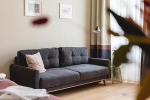 a living room with a gray couch in a room at Isabella Boutique Hotel in Sfântu-Gheorghe