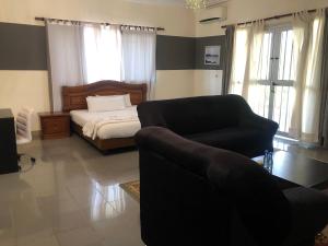 a living room with a bed and a couch and a chair at Hotel Le Littoral Des Almadies in Dakar